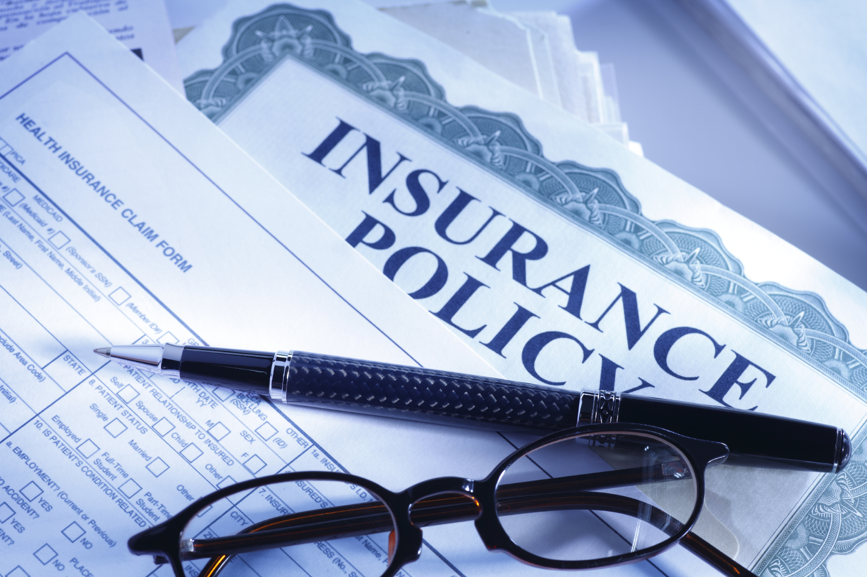 Glasses and Pen over Insurance Policy